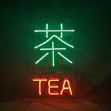 Neon sign featuring a large green Chinese character for tea above the word 'TEA' in red neon letters on a dark background.