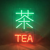 Vertical neon sign with a bright green Chinese character and red English word 'TEA' below it against a dark background.
