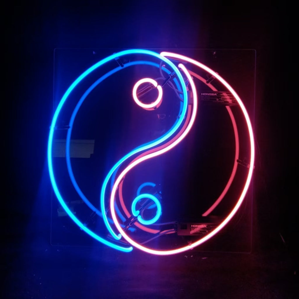 Neon sign shaped as a Yin Yang symbol with one half glowing blue and the other red, each side featuring a smaller circle in contrasting neon color.