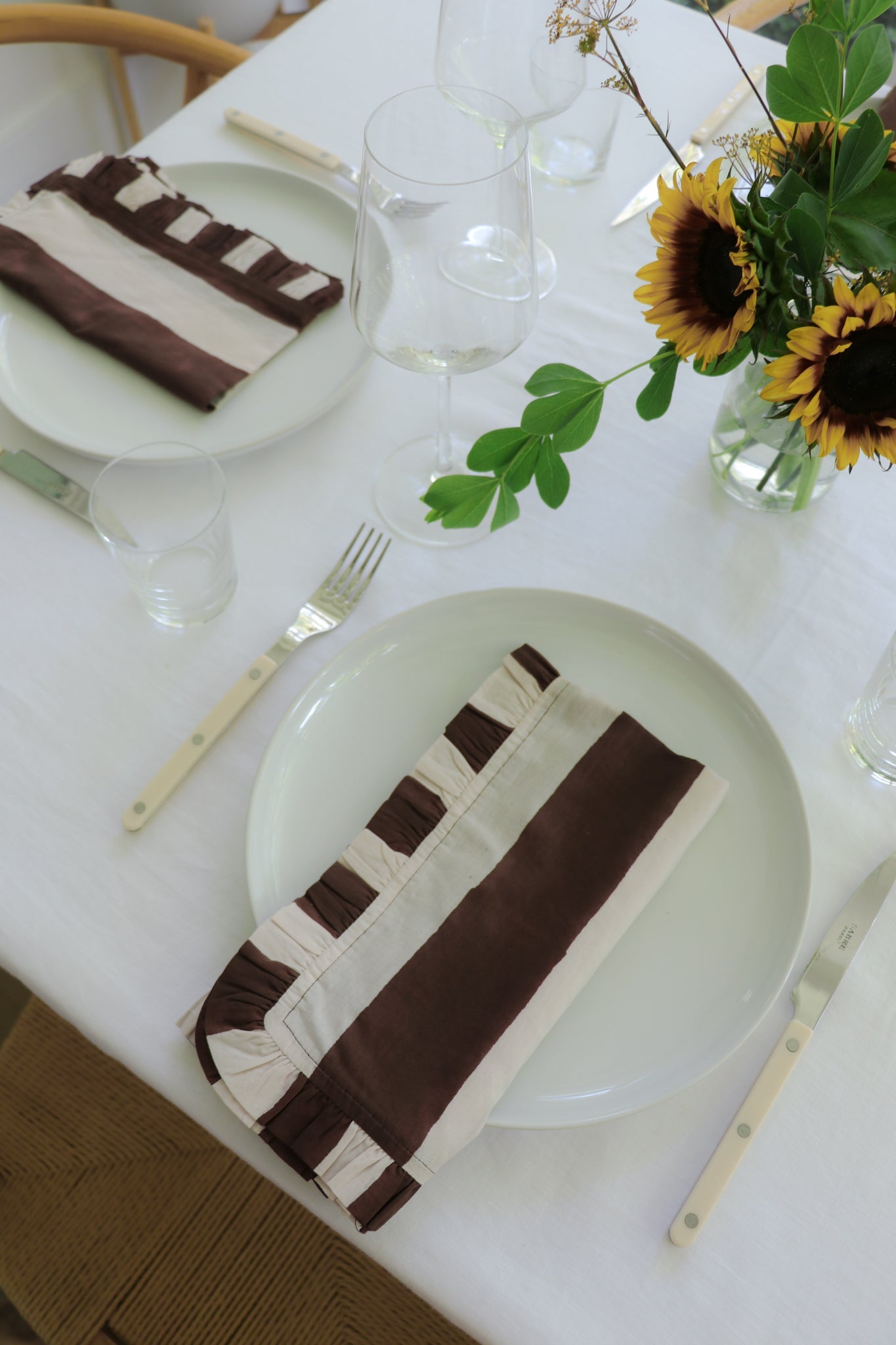 Set of four chocolate brown Cabana Stripe ruffled cotton napkins neatly stacked