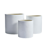 Three white cylindrical planters of varying sizes with smooth matte surfaces and wide open tops, arranged side by side against a white background.