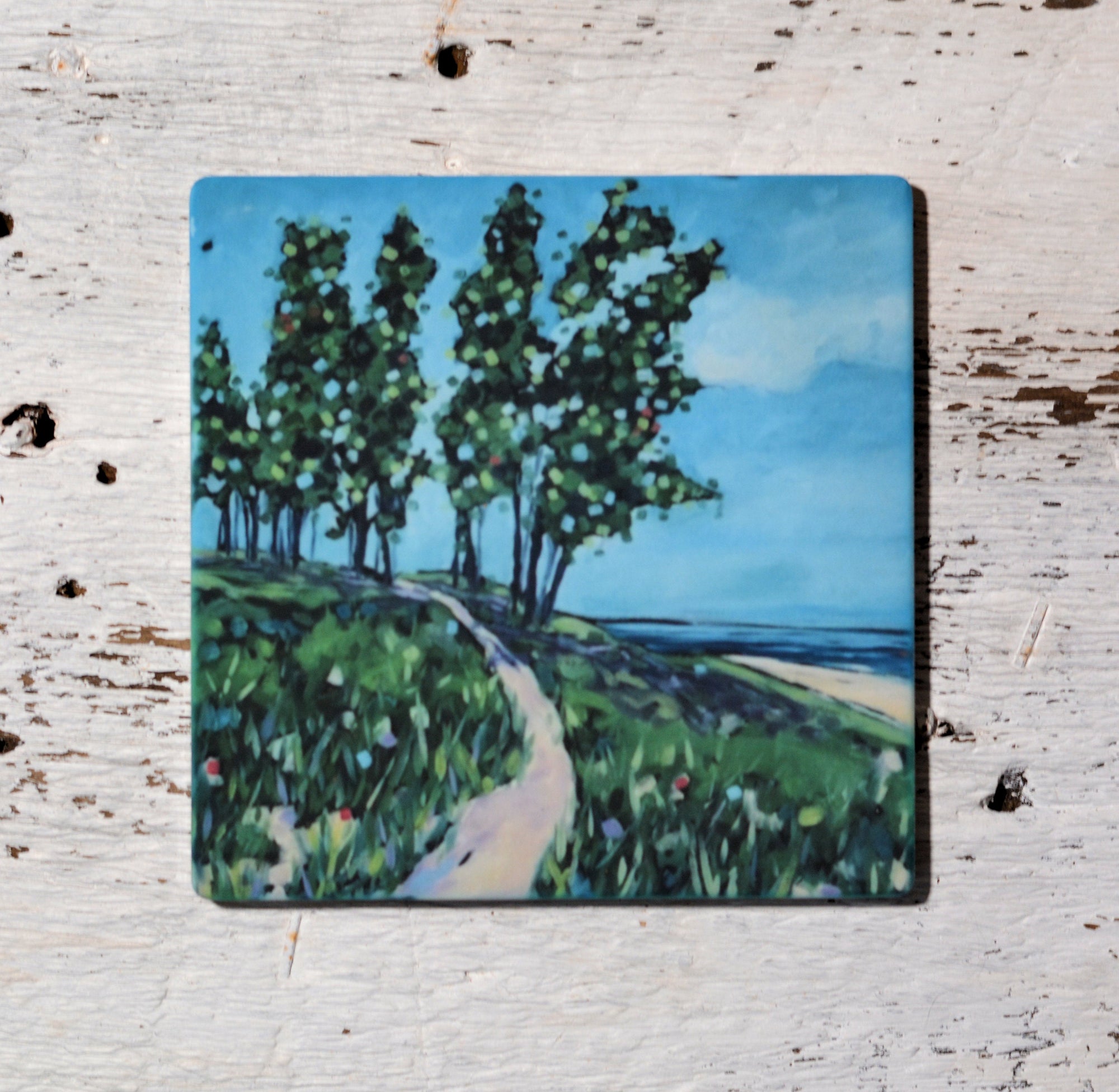 Brightly colored coasters and trivet inspired by coastal oil paintings by Christi Dreese