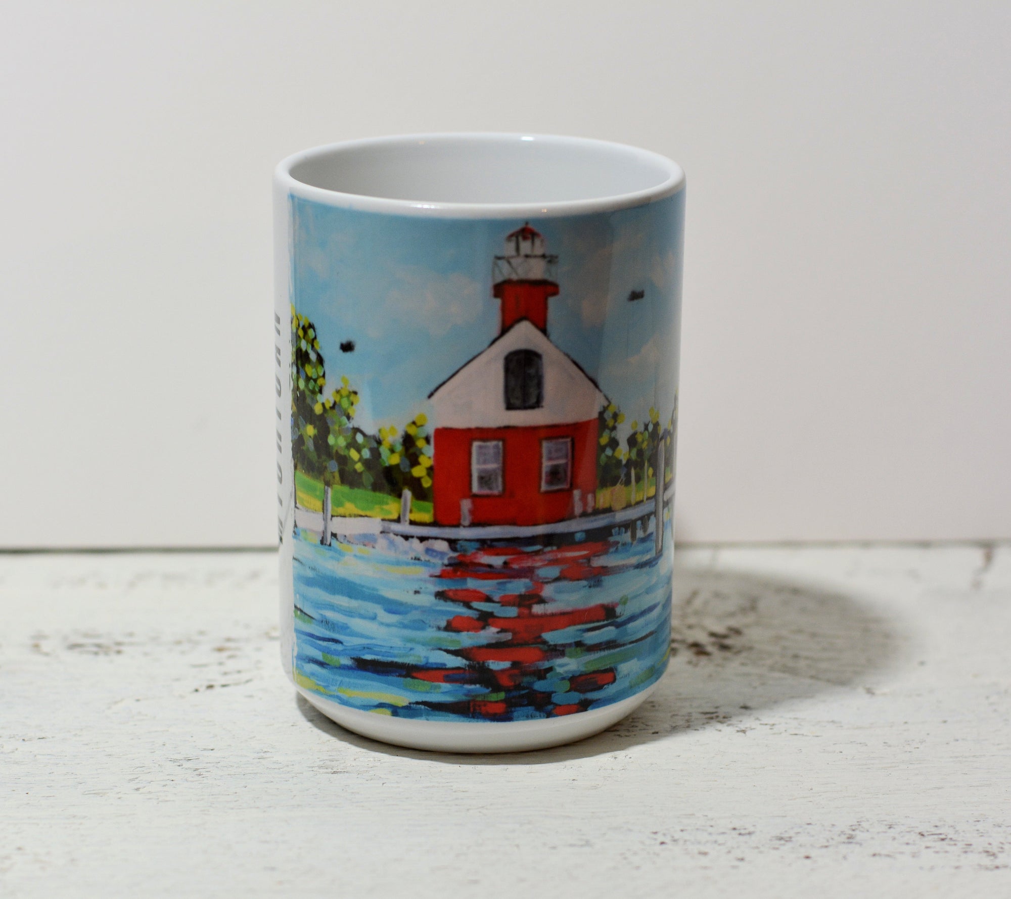 Ceramic mug featuring Saugatuck Lighthouse artwork by Christi Dreese