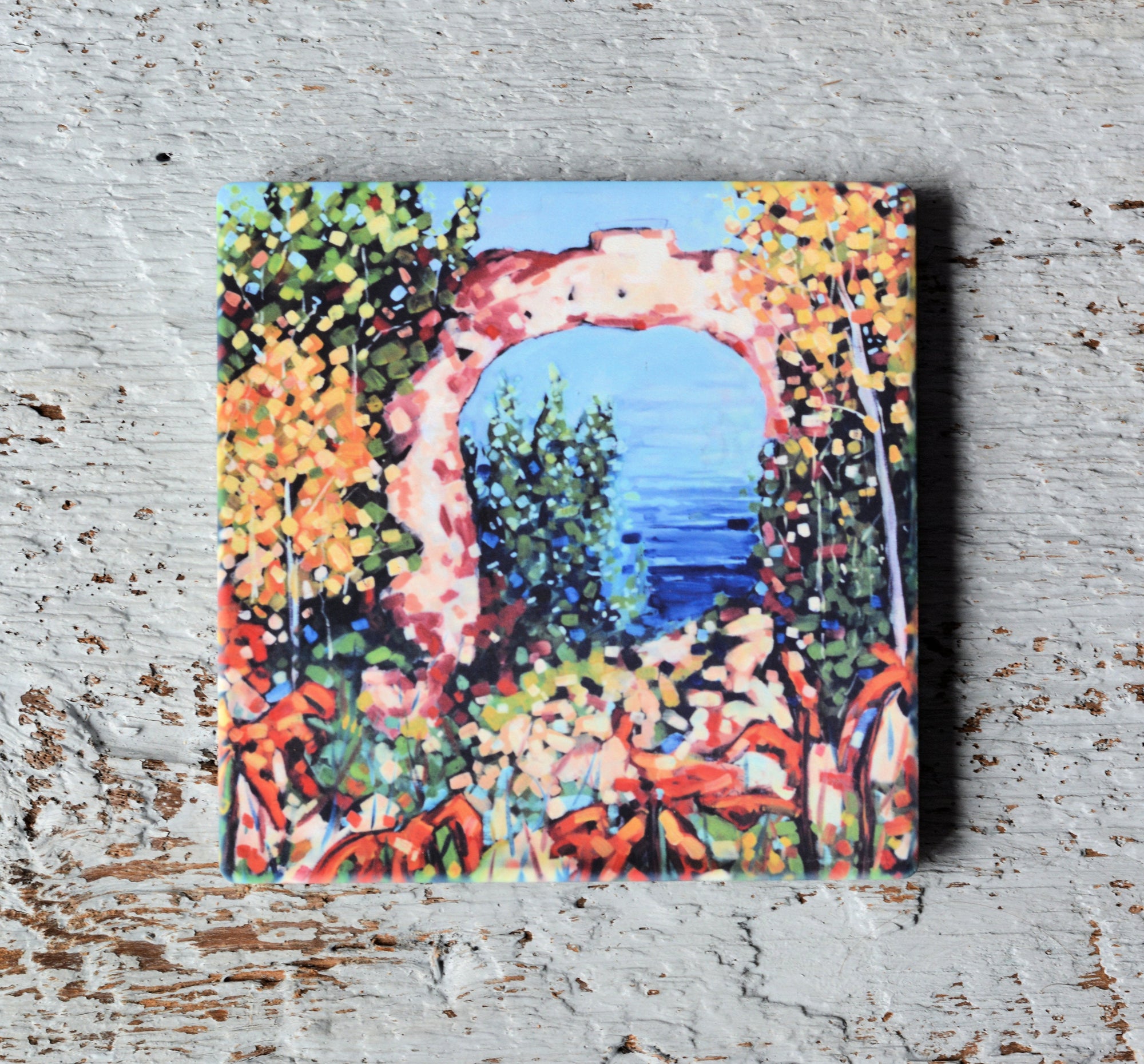 Bright art coaster featuring Mackinac Island Arch Rock on a bright blue background