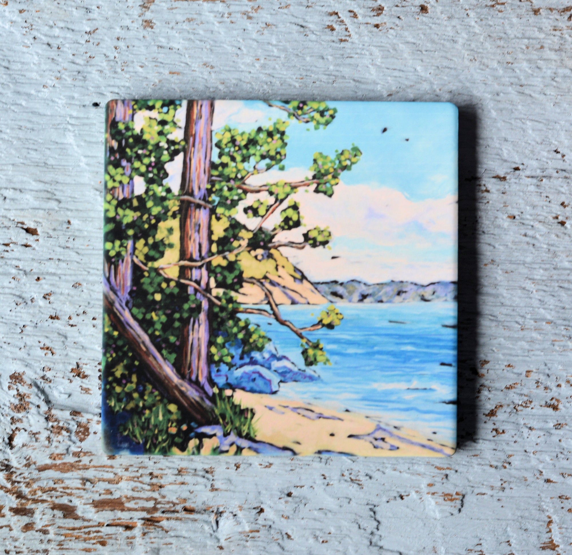 Coaster with bright, colorful artwork titled 'A Walk Along the Shoreline' featuring abstract coastal shapes and a cork backing shown beneath