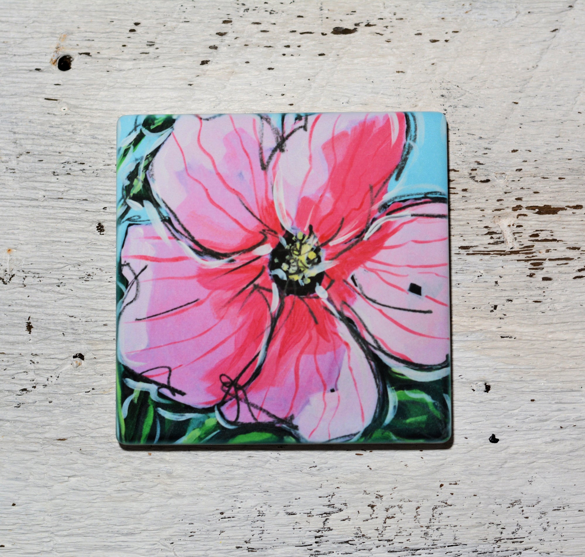 Bright pink hibiscus-themed coaster on sandstone texture