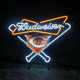 Neon sign featuring white and red Budweiser script above crossed baseball bats and a Cincinnati Reds home plate logo in orange and white on black background.