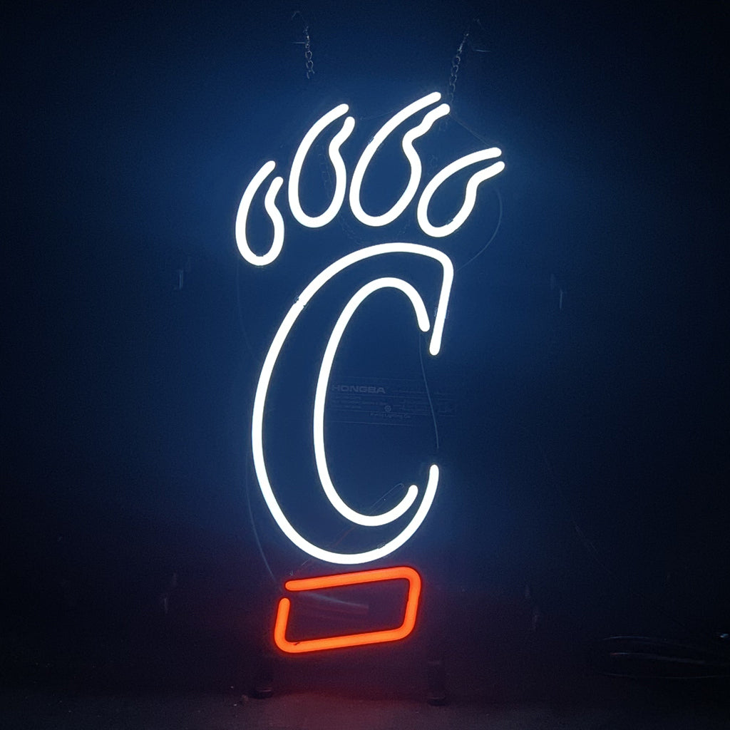Neon sign depicting a white Cincinnati Bearcats paw with a large "C" and a red rectangular underline, glowing against a dark background.
