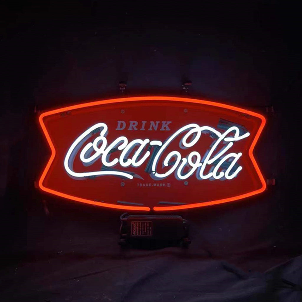 Red and white neon sign shaped like a bowtie with 'Drink Coca-Cola' in cursive font glowing against a dark background.
