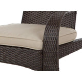 Close-up of dark brown woven wicker chair arm with thick beige cushion, showing textured basket-like pattern and soft seating detail.