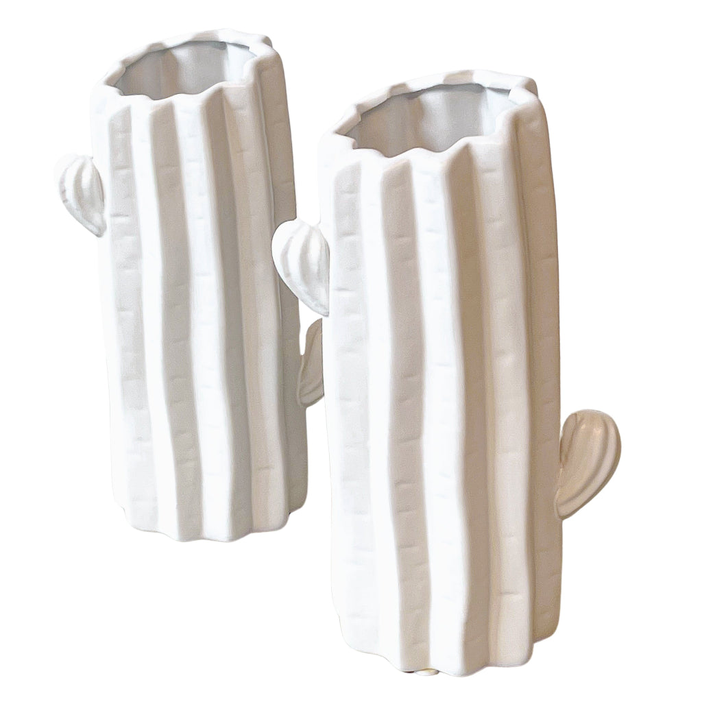 Pair of white ceramic Consolea vases shaped like cactus forms, set on a white surface with textured shadows