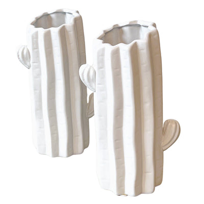 Pair of white ceramic Consolea vases shaped like cactus forms, set on a white surface with textured shadows