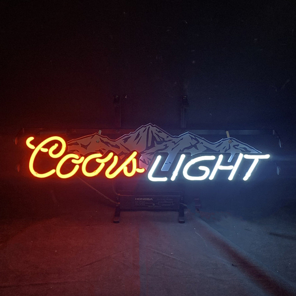 Neon sign with a red script 'Coors' and white block 'LIGHT' letters, featuring blue and white mountain peaks behind the text on a dark background.
