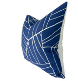 Royal blue pillow with white geometric line pattern, shown at an angle revealing a plain white back panel and a slightly puffed, soft texture.