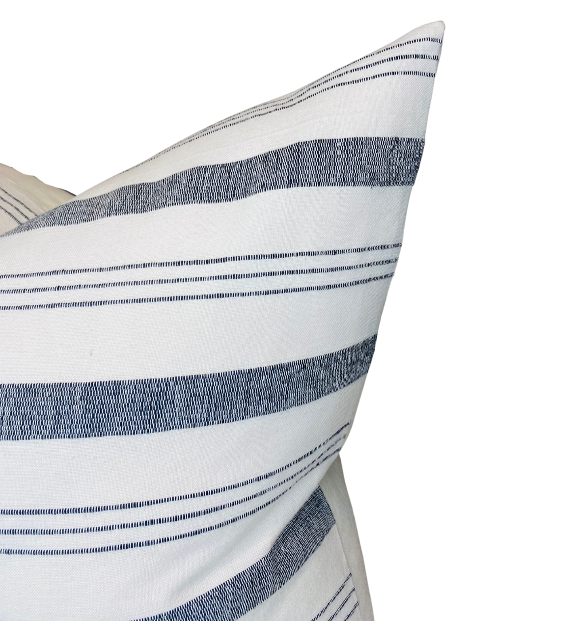 Close-up of a pillow cover featuring natural fabric with alternating wide and thin horizontal navy blue stripes on a white background.