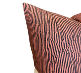 Salmon-colored pillow cover with vertical black stripes and abstract black linear patterns creating a textured, dynamic look.