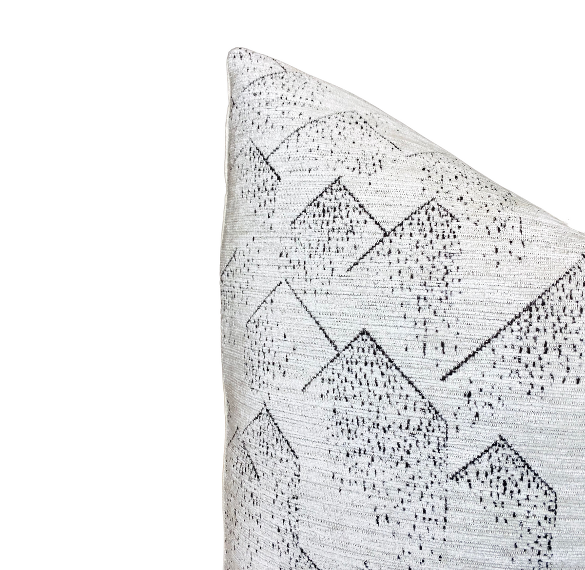 Corner of a Brink Pillow Cover in graphite ivory featuring a subtle geometric pattern of outlined cubes and small black dots on textured fabric