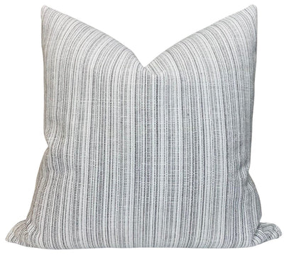 Veranda Strie Pillow Cover in Grey displayed on a cream sofa with a dark background