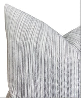 Close-up of a grey pillow cover with fine vertical strie pattern in alternating light and dark grey threads, showing texture and sharp corner details.