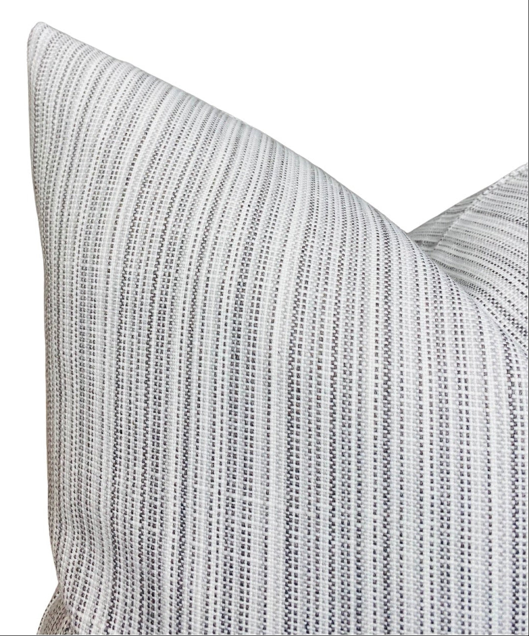 Close-up of a grey pillow cover with fine vertical strie pattern in alternating light and dark grey threads, showing texture and sharp corner details.