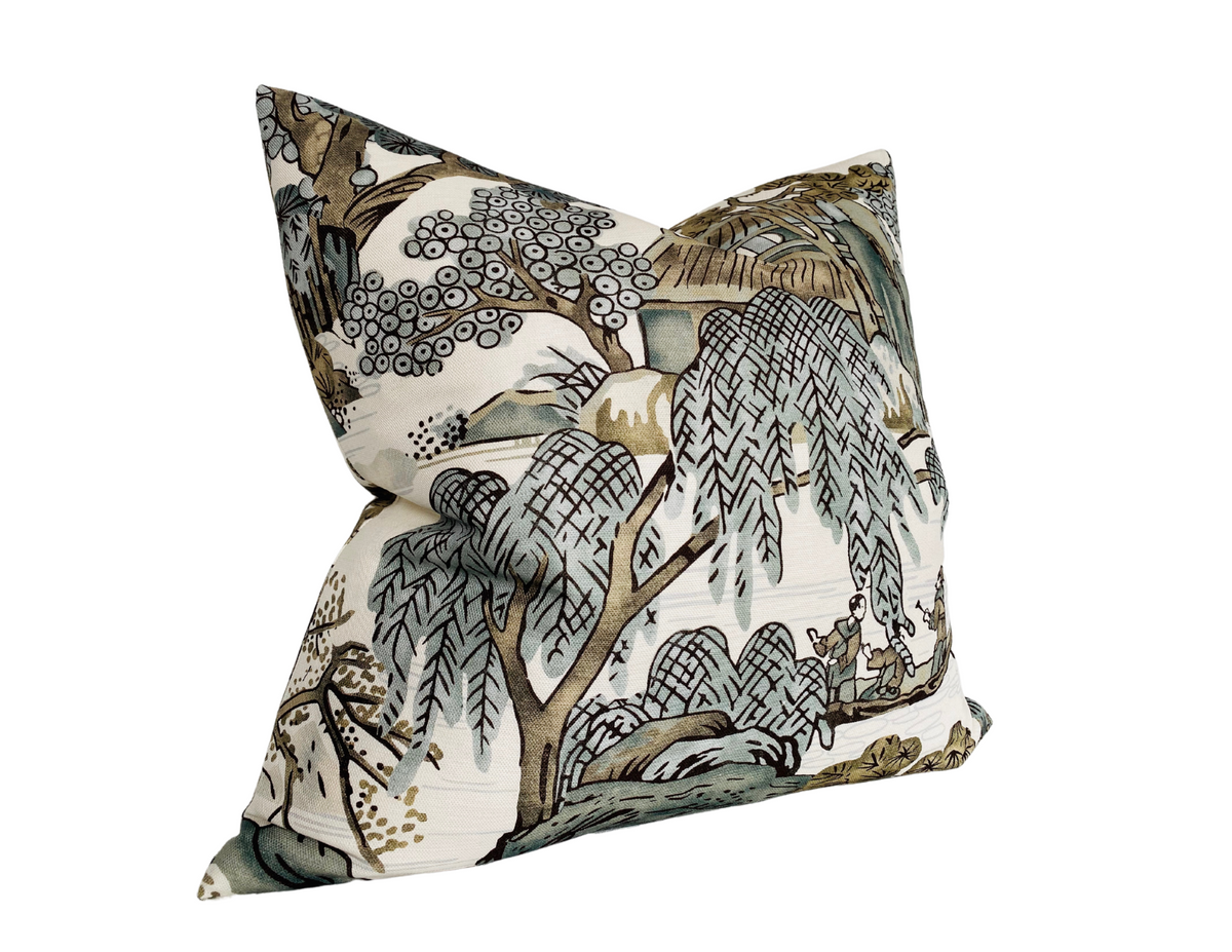 Decorative pillow with an Asian-inspired scenic print featuring willow trees, water, and traditional buildings in muted grey, brown, and green tones on a light background.