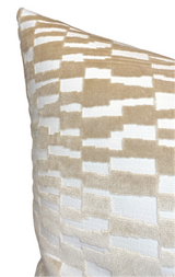 Close-up of a pillow corner featuring a tan brown and white geometric pattern with a soft velvet texture.