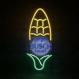Neon sign shaped like an ear of corn with yellow kernels and green husk surrounding a blue and white Busch Light beer logo at the center, mounted on a black background.