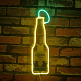 Corona Extra Bottle with Lime Neon Sign lit on a wall with yellow and green glowing neon tubes on metal grid backing