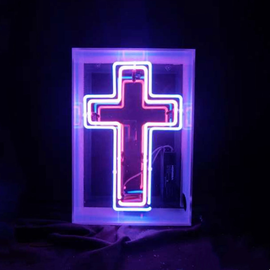 Illuminated cross acrylic box neon sign glowing indoors