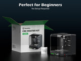 Cubiko desktop CNC router kit assembled in black and transparent casing next to its open white and green box with product image and branding, with a small carved butterfly detail.