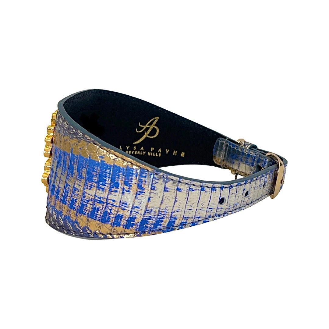 Wide bracelet with blue and gold textured leather and a gold lion head detail, viewed from an angle showing its curved shape and buckle.