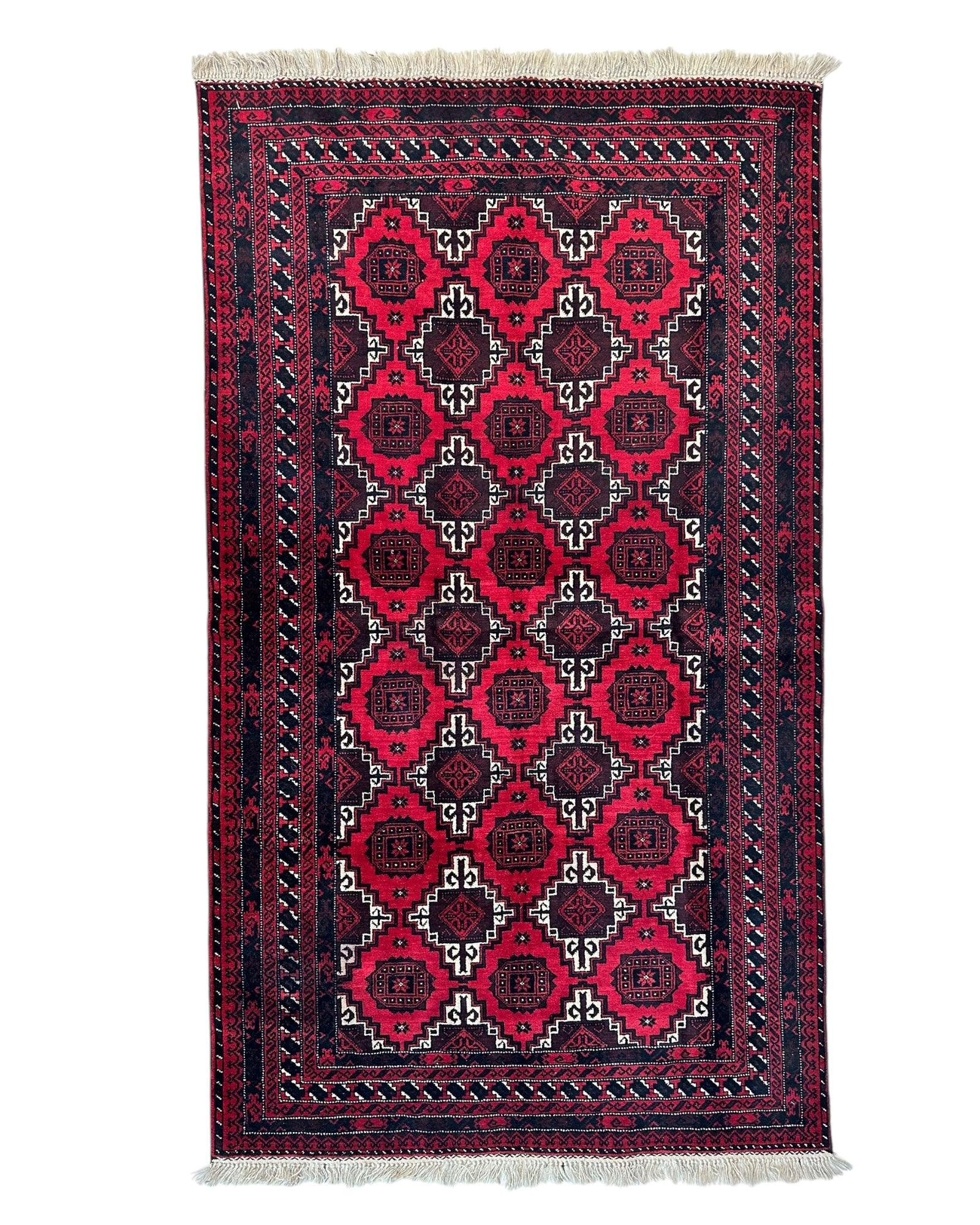 Hand-knotted Afghani Baluch wool rug showing geometric pattern in earth tones