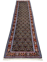 Long Persian Senneh runner rug with dense floral motifs in dark brown, red, and cream, featuring multiple decorative borders and fringed ends.