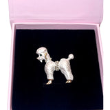 Pearl White Poodle Brooch by Allysa Payne Beverly Hills displayed on brown fabric