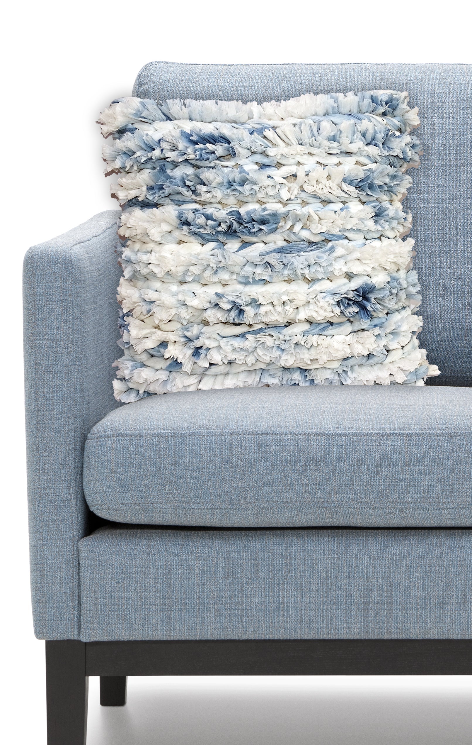 Blue and white furry throw pillow cover with zipper closure on a fabric surface