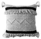 Throw pillow with black and beige stripes and tassels at corners on a sofa