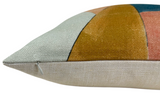 Close-up of a rectangular pillow with geometric color blocks in apricot, muted teal, and mustard on textured woven fabric, featuring a concealed zipper along the edge.