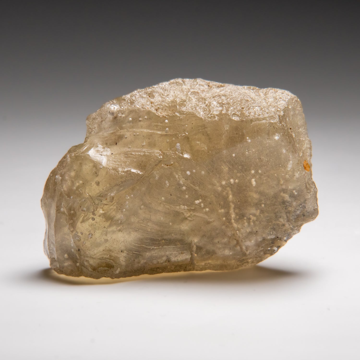 Close-up image of Genuine Libyan Desert Glass, a rough translucent yellow-green desert glass specimen