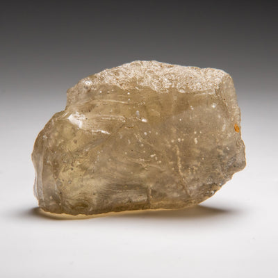 Close-up image of Genuine Libyan Desert Glass, a rough translucent yellow-green desert glass specimen
