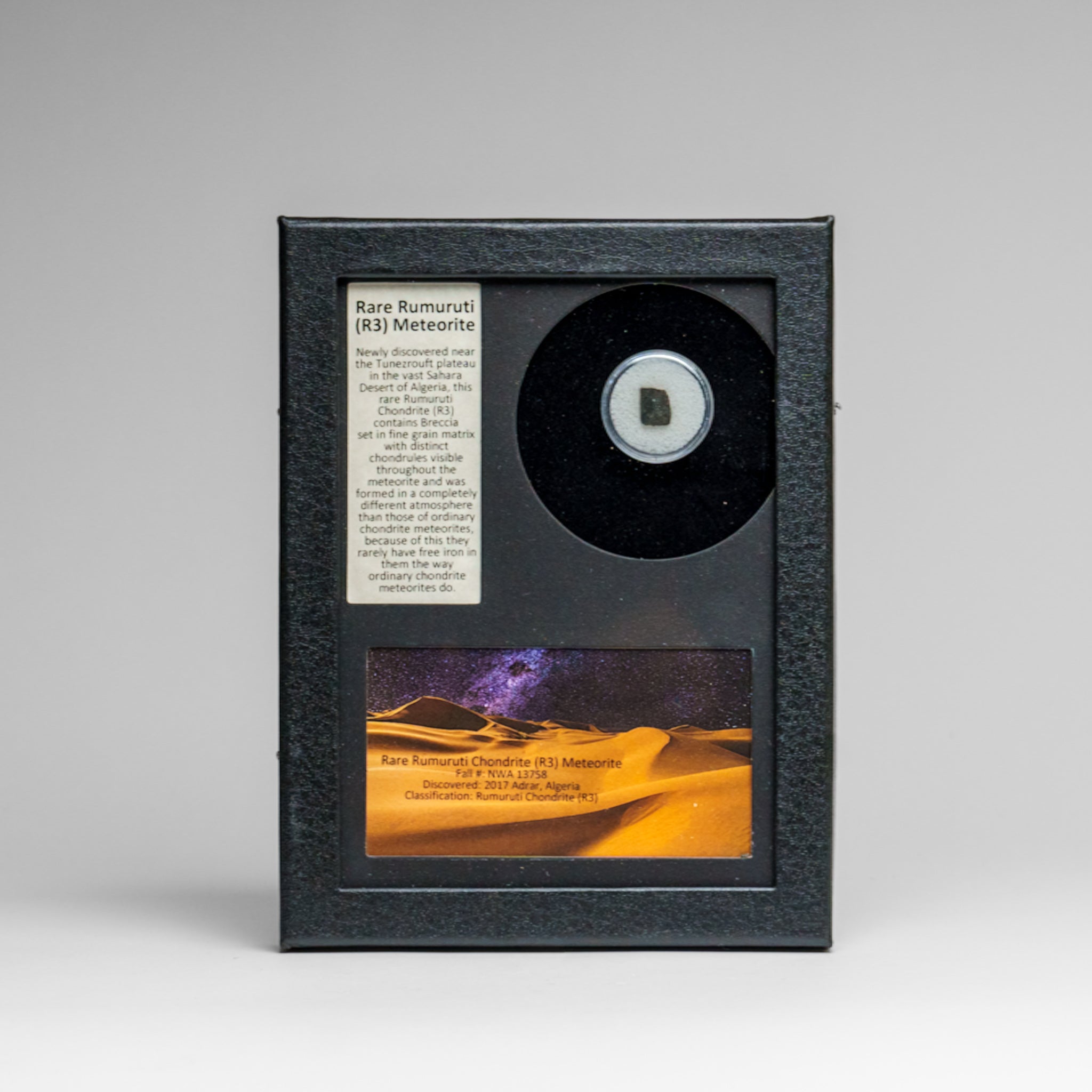 Rare Rumuruti (R3) meteorite shown in a glass display box, exhibiting breccia and visible chondrules