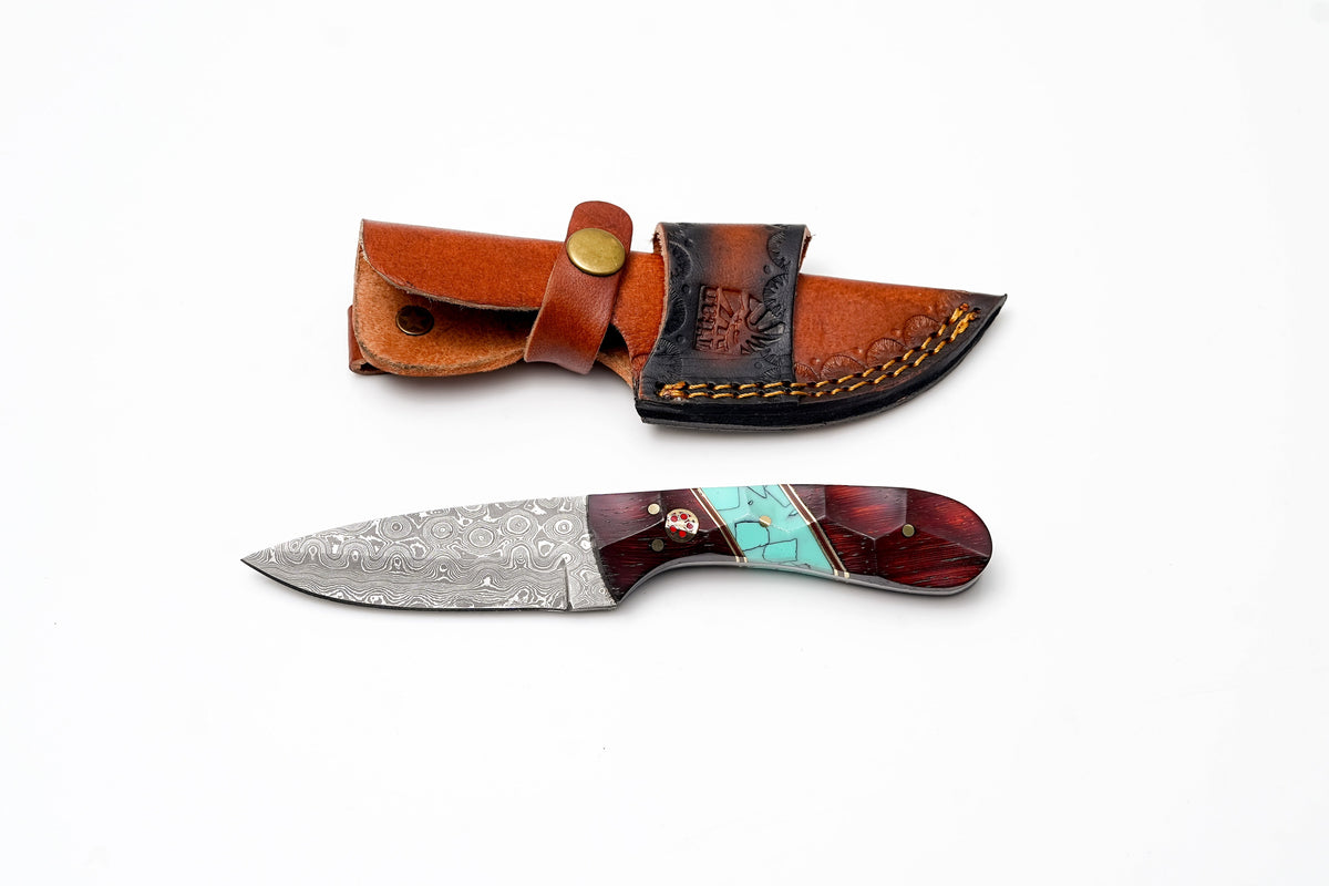 Damascus Steel Drop Point Hunter knife with faceted rosewood and turquoise handle next to leather sheath