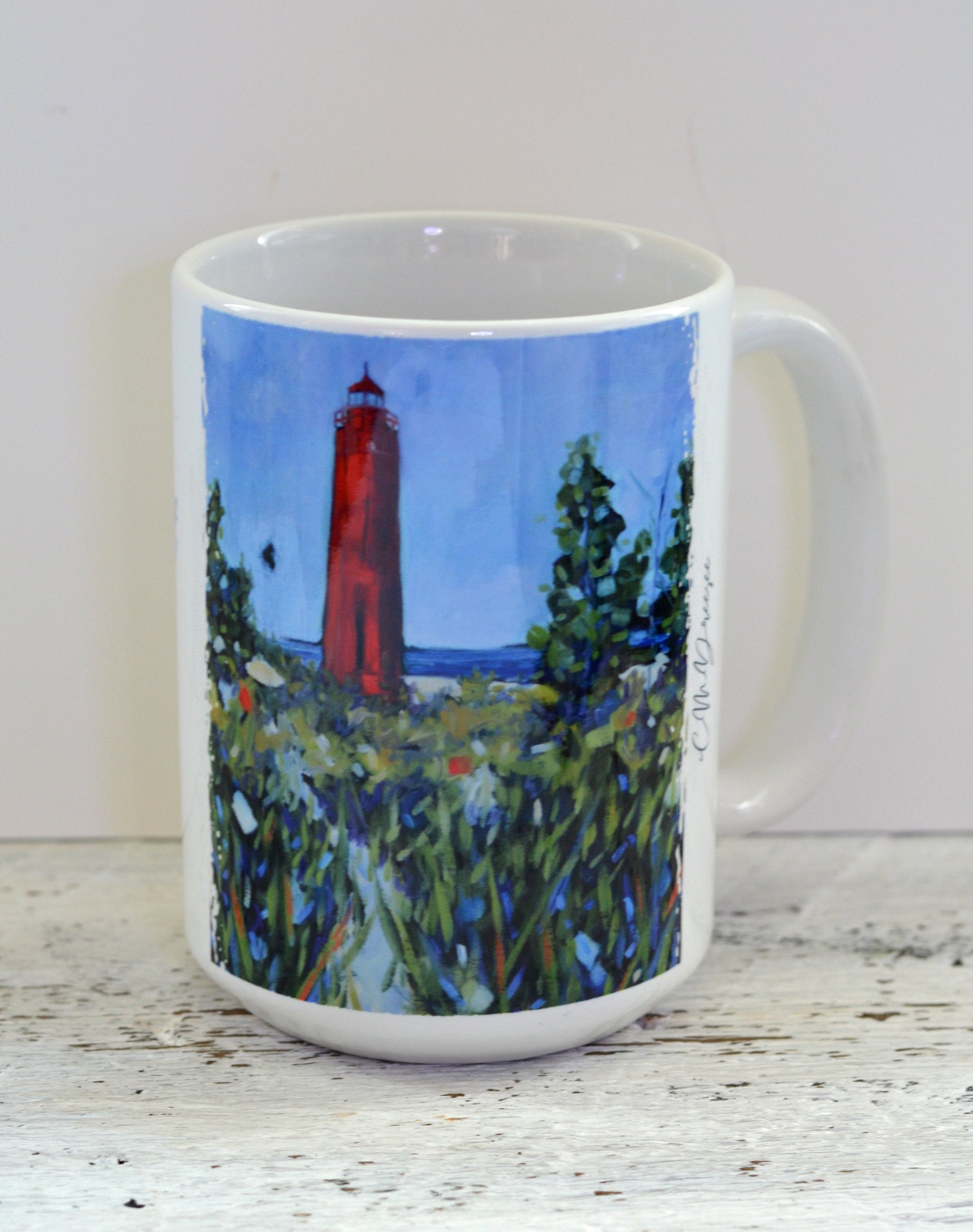 Ceramic mug and stainless-steel tumbler featuring Little Sable Point Lighthouse design by Christi Dreese.