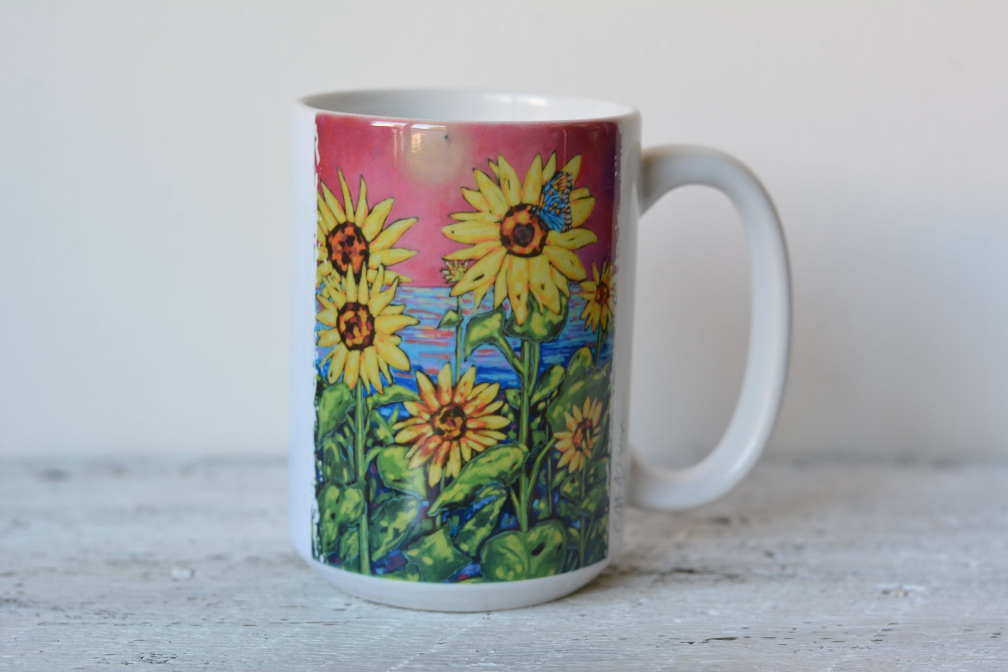 Ceramic mug and stainless steel tumbler displaying original artwork by Christi Dreese