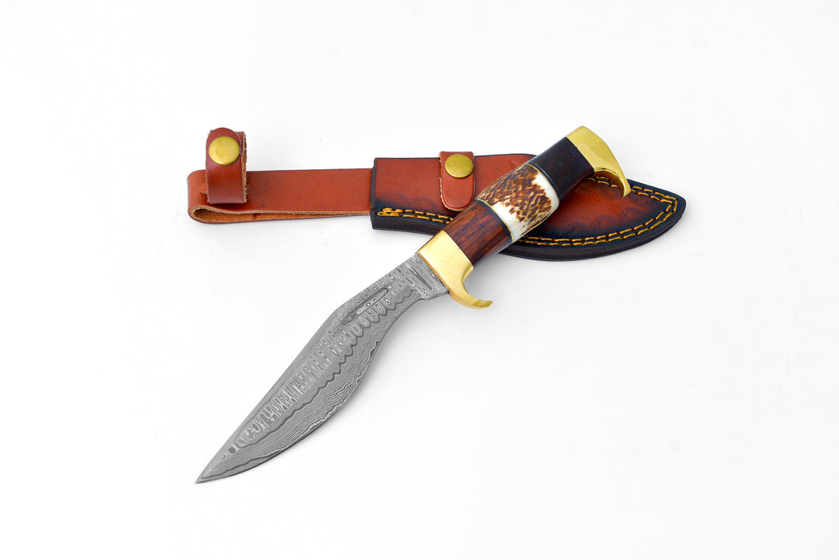 Damascus steel chopping knife with a curved blade, stag antler and walnut wood handle, alongside a brown leather sheath with brass button closures.