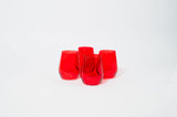Four stemless wine glasses made of translucent cherry red glass, arranged in a diamond shape on a white background.