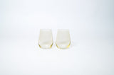 Two translucent lemon-yellow tinted wine glasses with a subtle gradient, shown side by side against a plain white background.