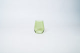 Matcha Green Stemless Colored Wine Glass from glasshauseco shown on a neutral surface with green and blue neighboring glasses