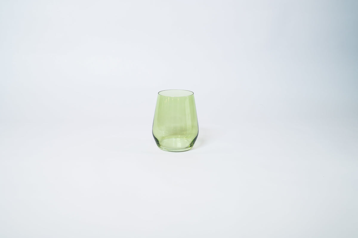 Matcha Green Stemless Colored Wine Glass from glasshauseco shown on a neutral surface with green and blue neighboring glasses