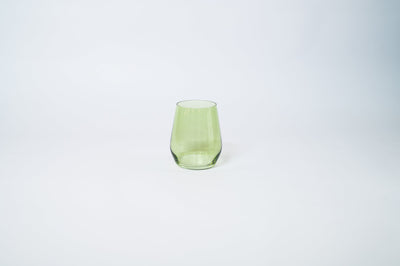 Matcha Green Stemless Colored Wine Glass from glasshauseco shown on a neutral surface with green and blue neighboring glasses