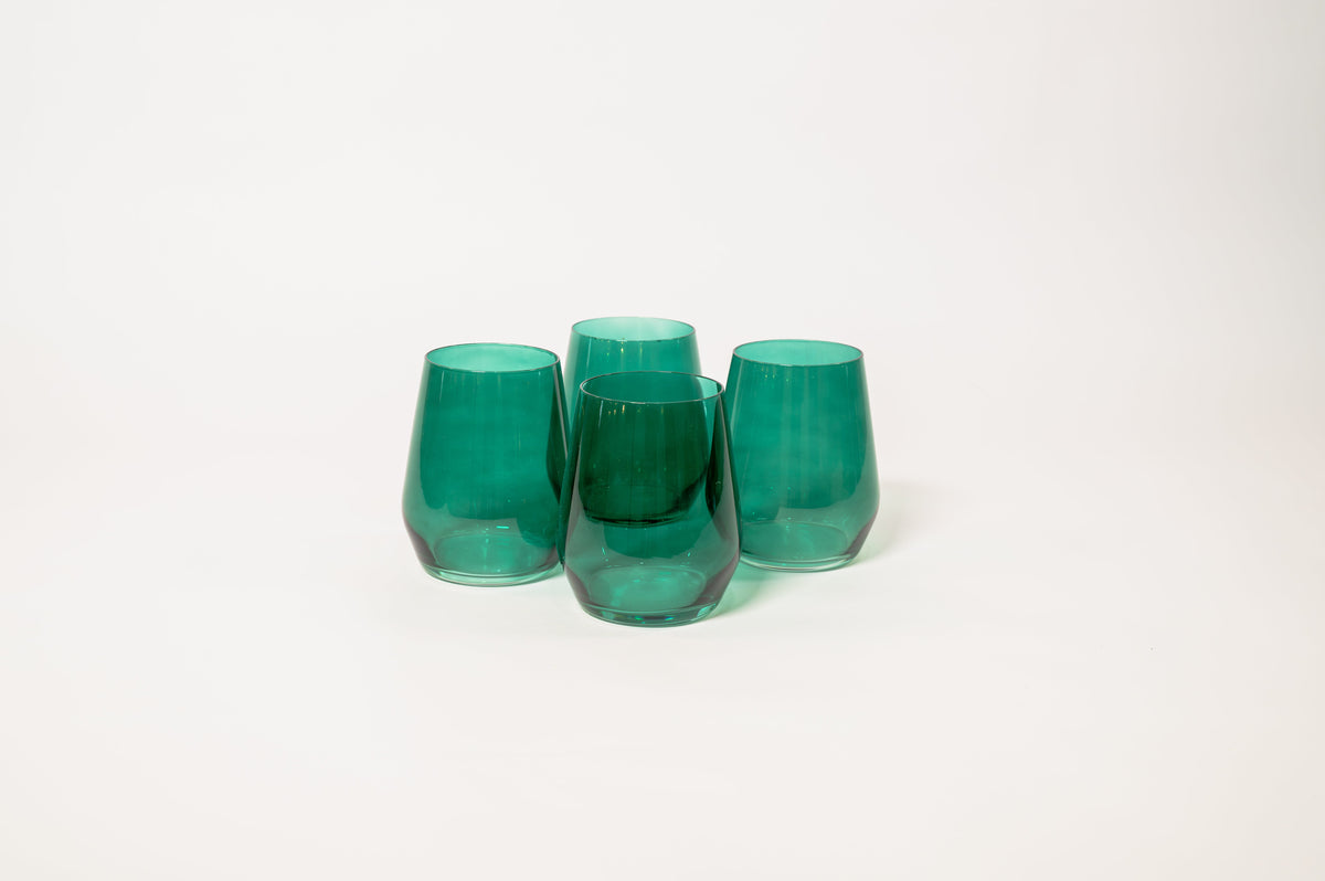 Four emerald green stemless wine glasses with smooth rounded shapes grouped on a plain white background.